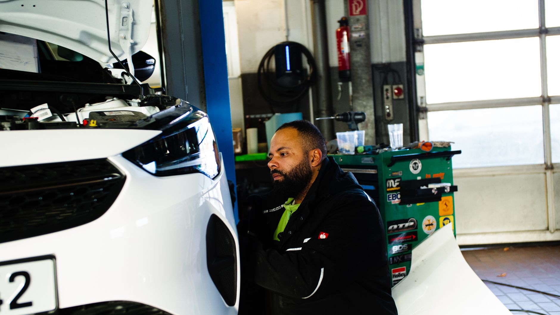 Mechanic working on a car engine in a modern workshop in Gladbeck, NRW, Germany.