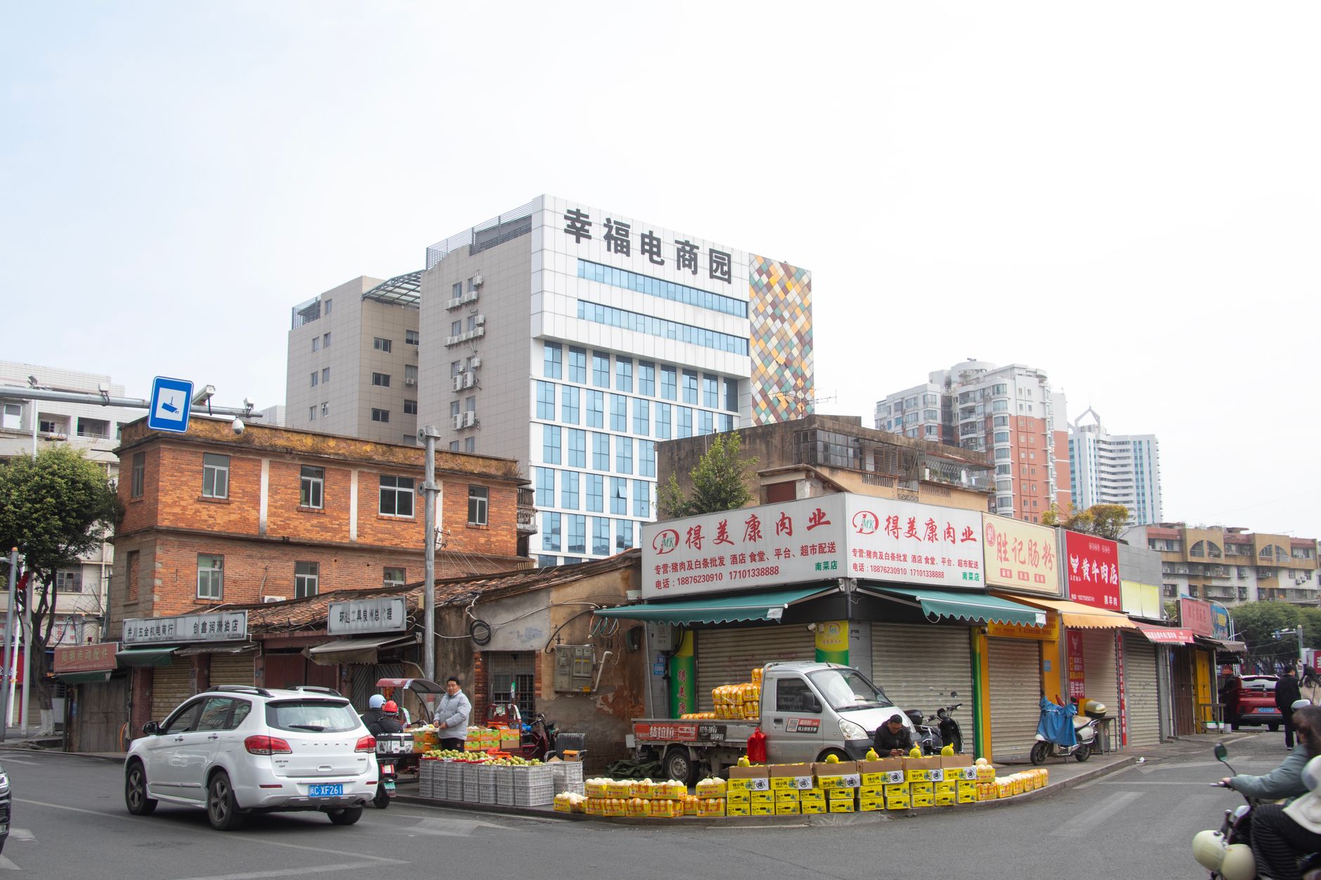 Quanzhou street scene featuring local market stalls, modern buildings, and vehicles in Fujian, China.