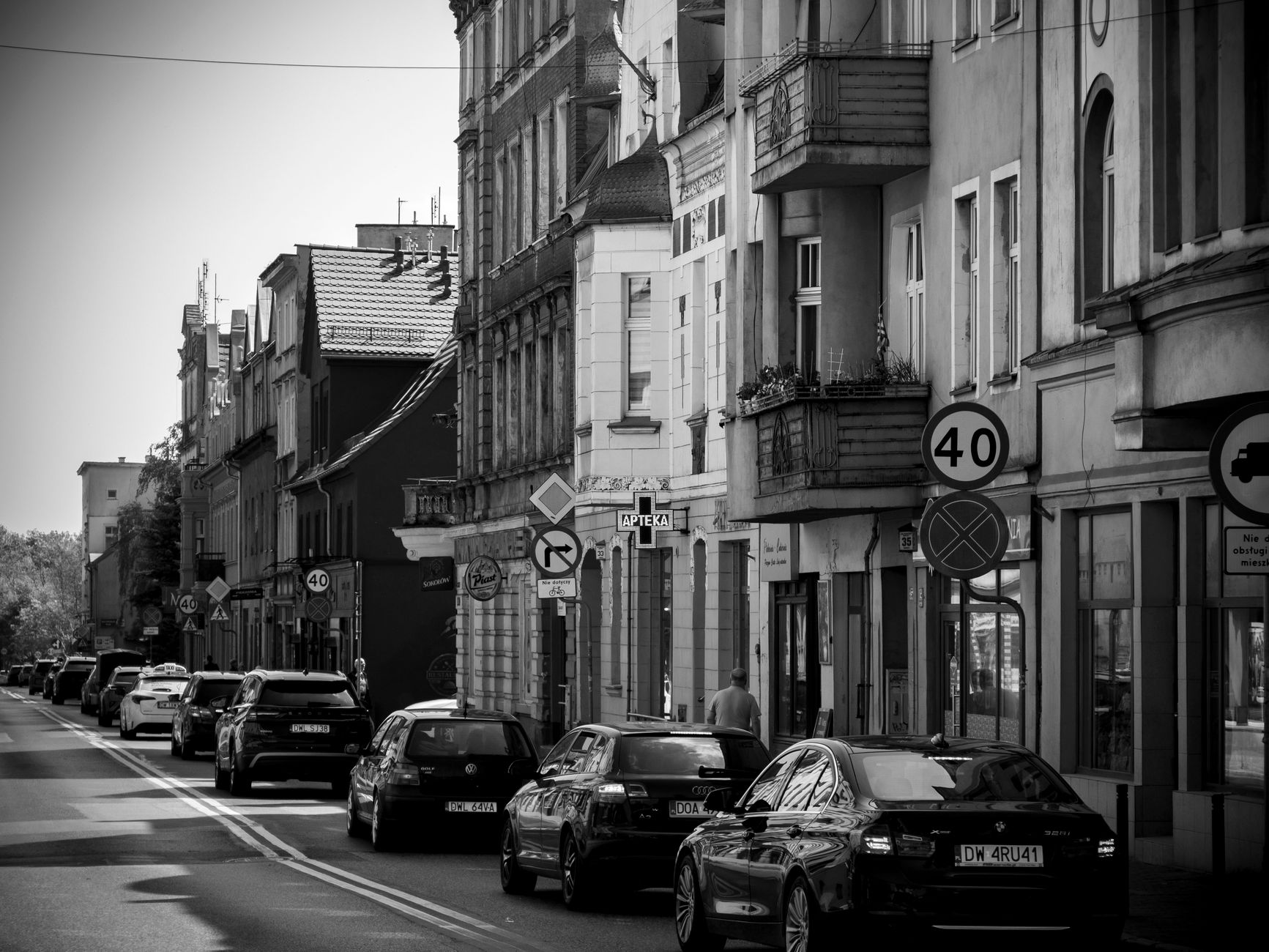 Monochrome image of a busy street in Wrocław, Poland showing cars and European architecture.