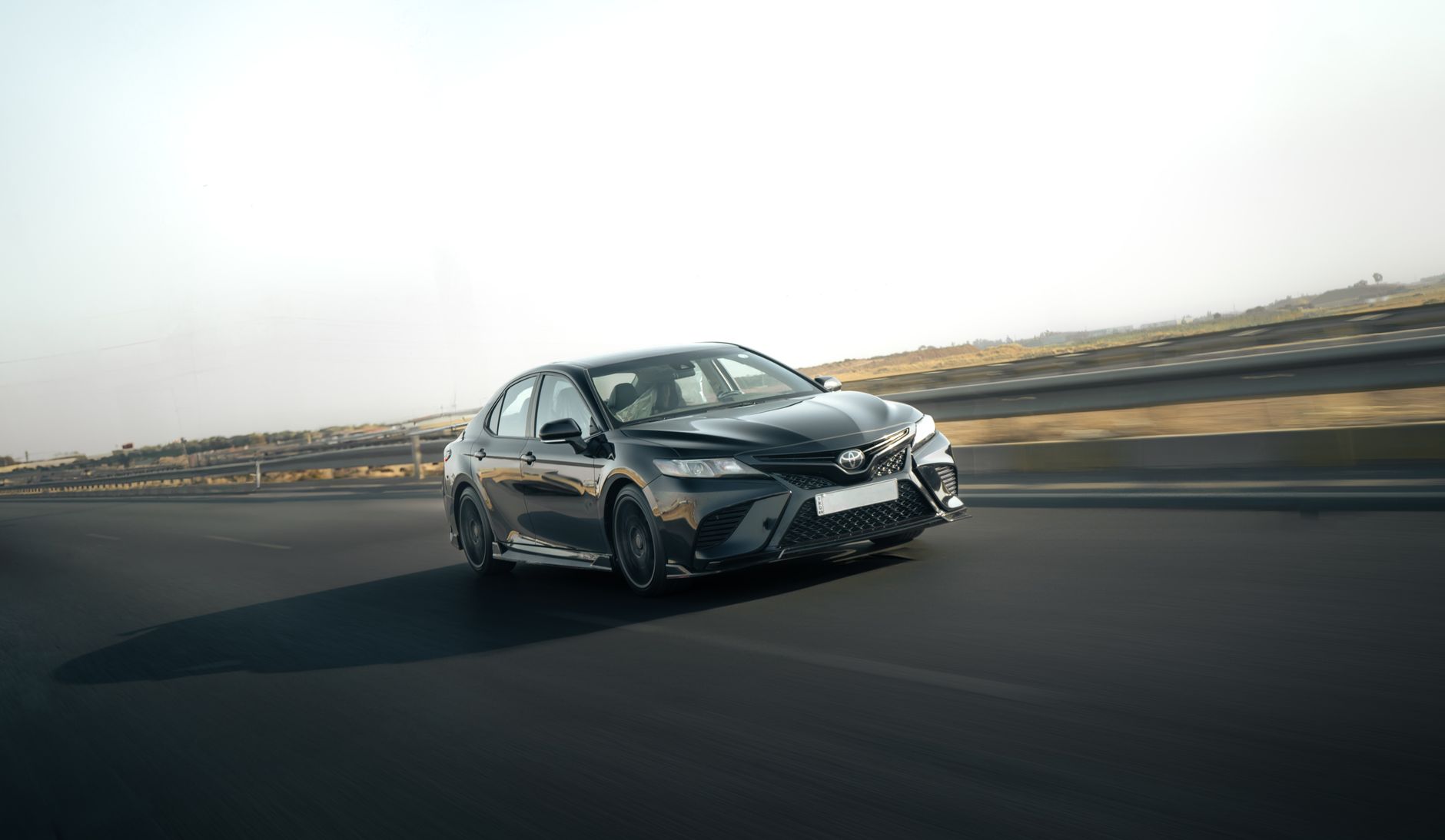 A sleek Toyota Camry in motion on a highway, capturing the essence of speed and style.