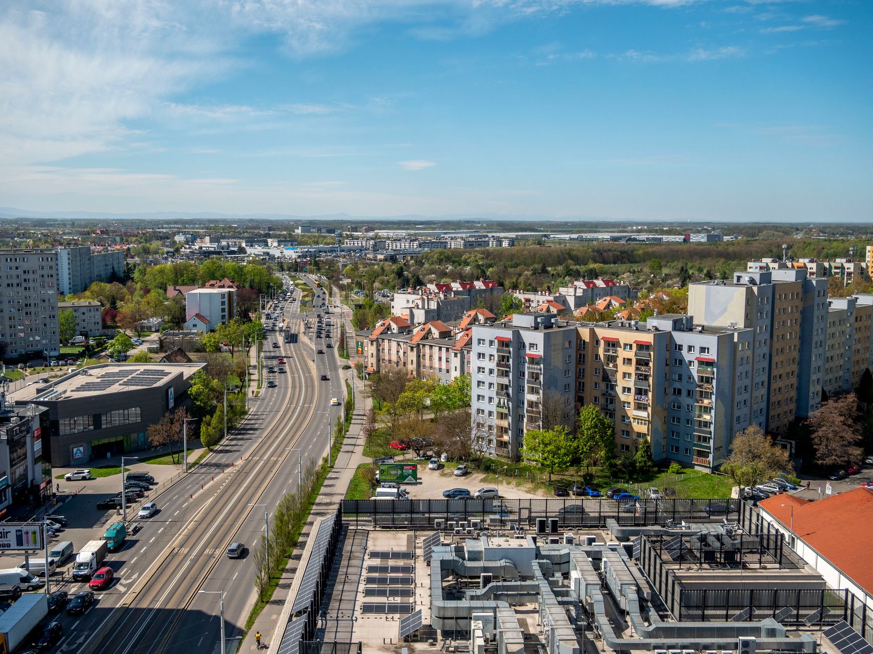 Urban cityscape of Wrocław, Poland, showcasing residential buildings and roads under a bright sky.