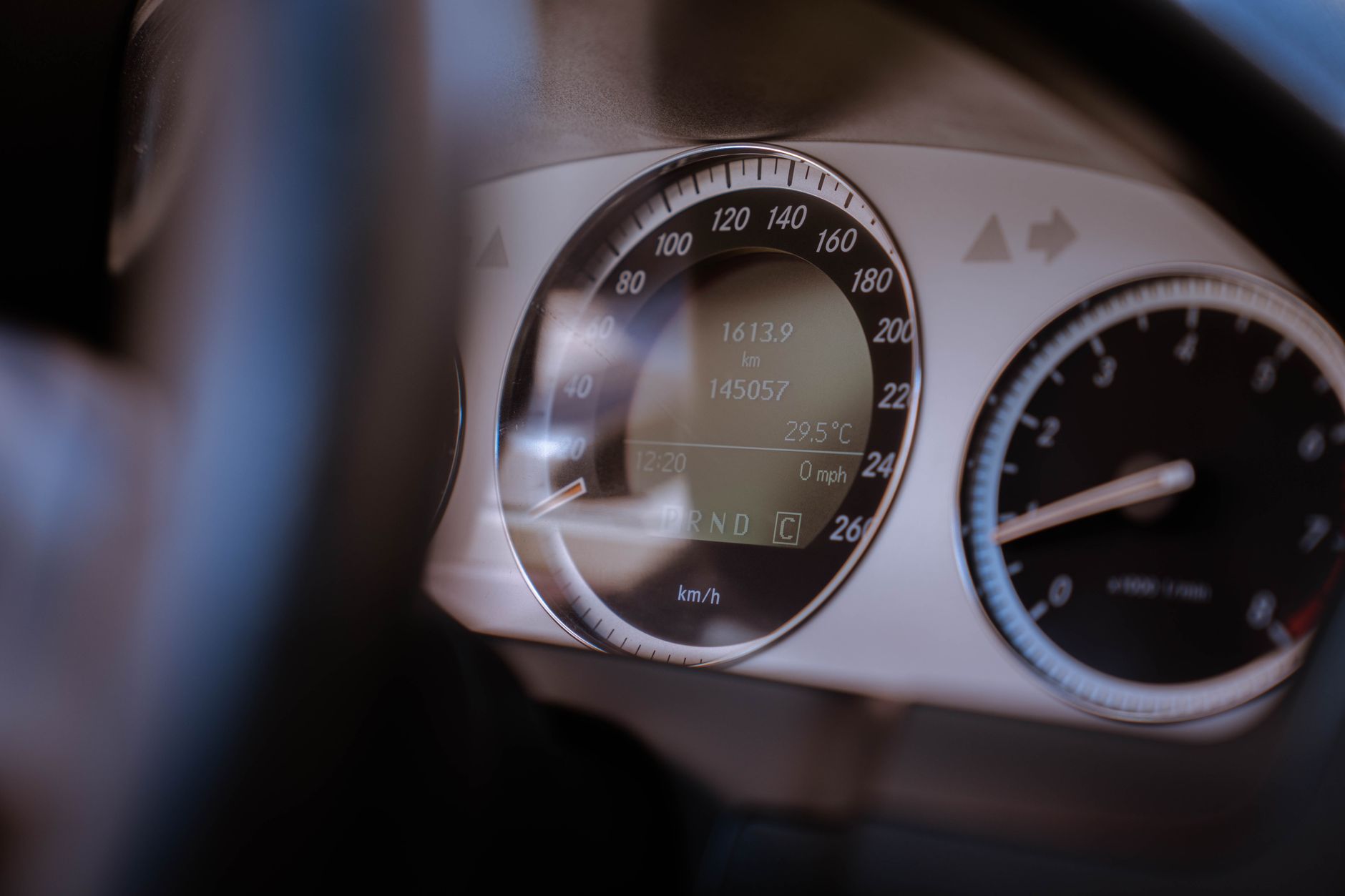 Close-up view of a car dashboard showing speedometer and digital display with readings.
